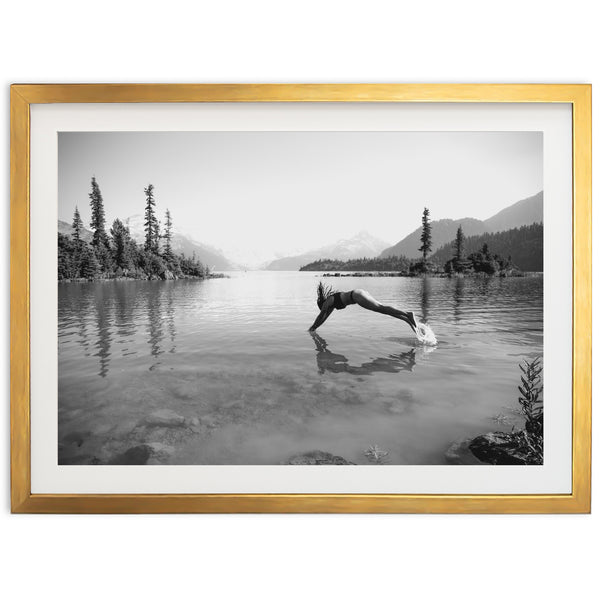 a black and white photo of a person diving into a lake