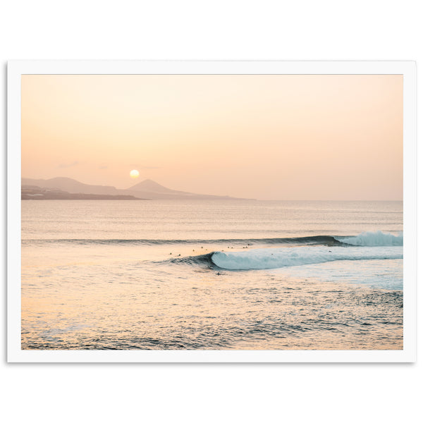 a surfer riding a wave in the ocean at sunset