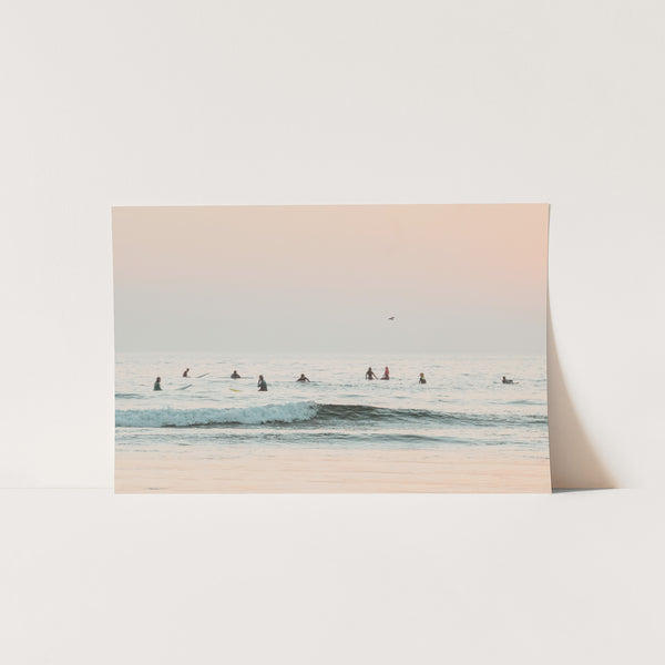 a group of people riding surfboards on top of a wave