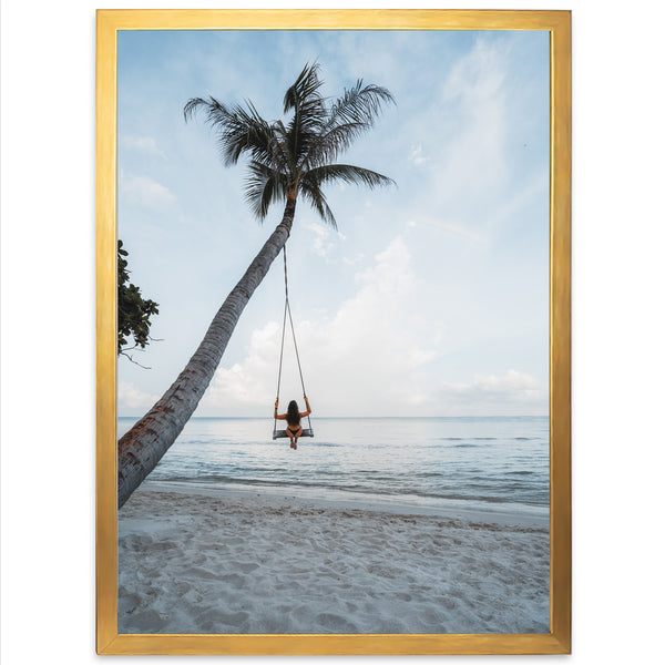 a woman sitting on a swing between two palm trees