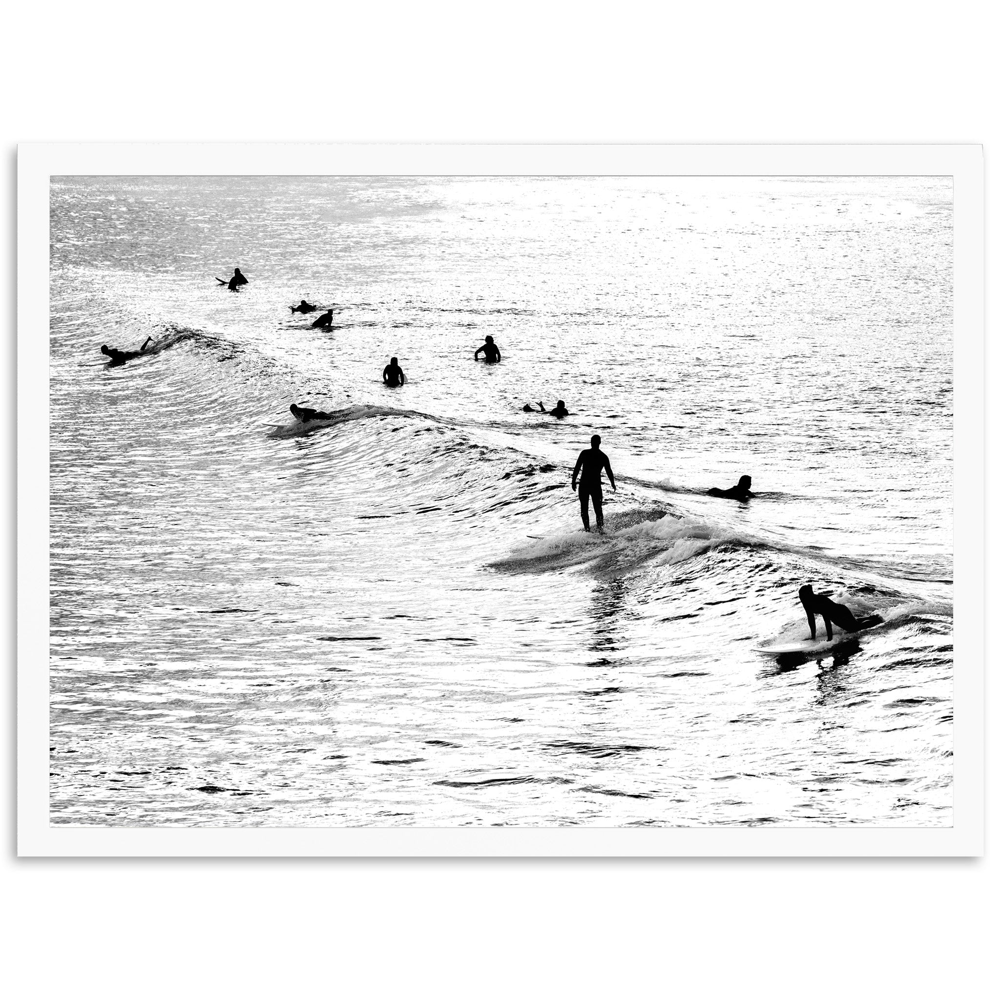 a black and white photo of people surfing in the ocean