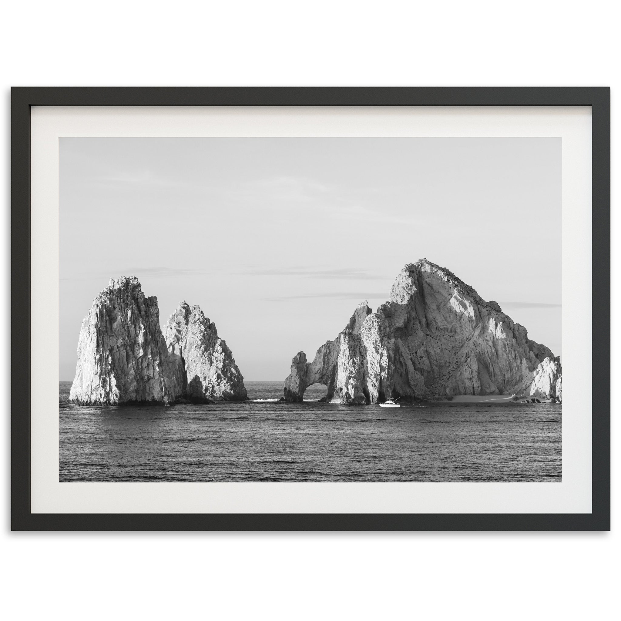 a black and white photo of rocks in the ocean