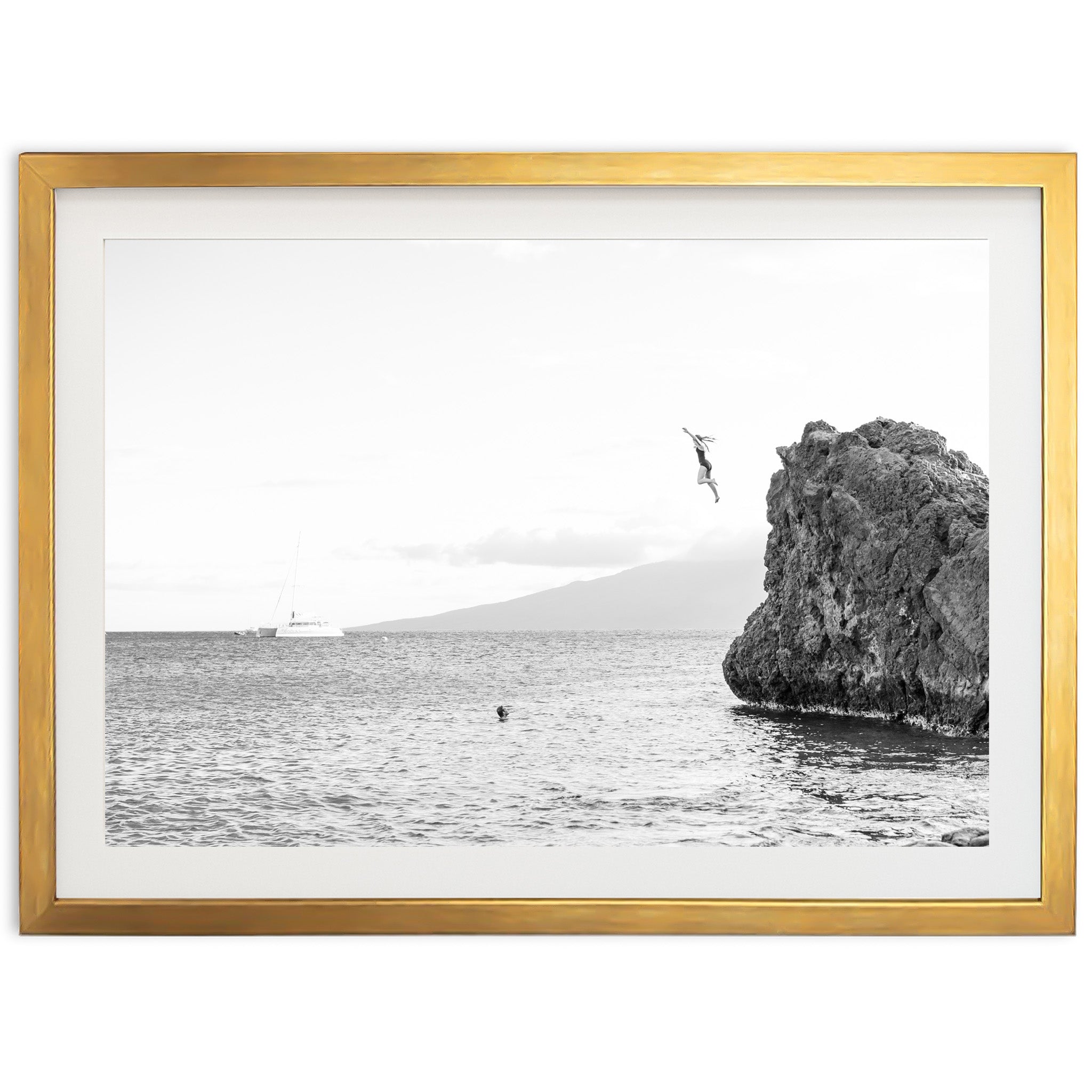 a black and white photo of a bird flying over a body of water