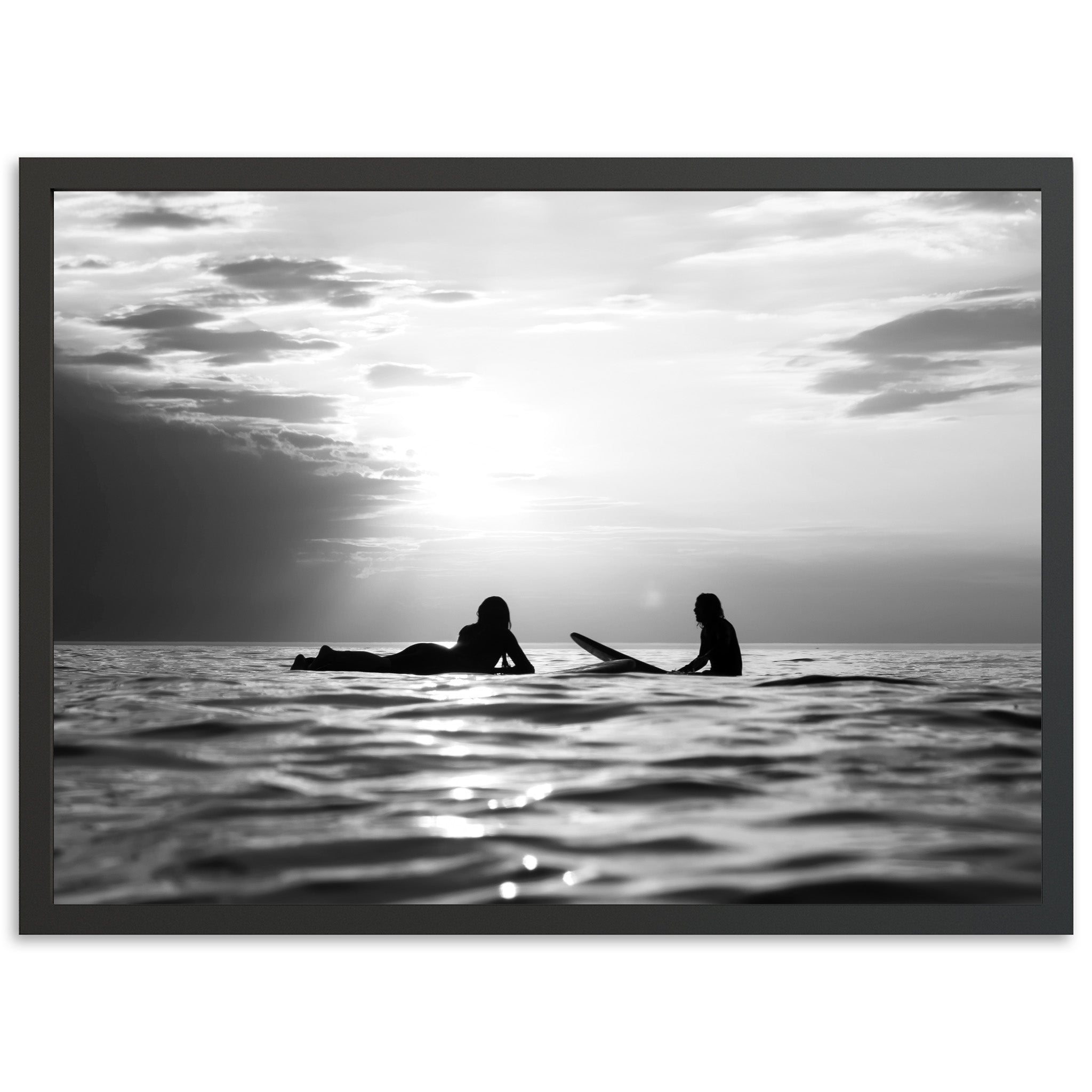 a black and white photo of two people on surfboards