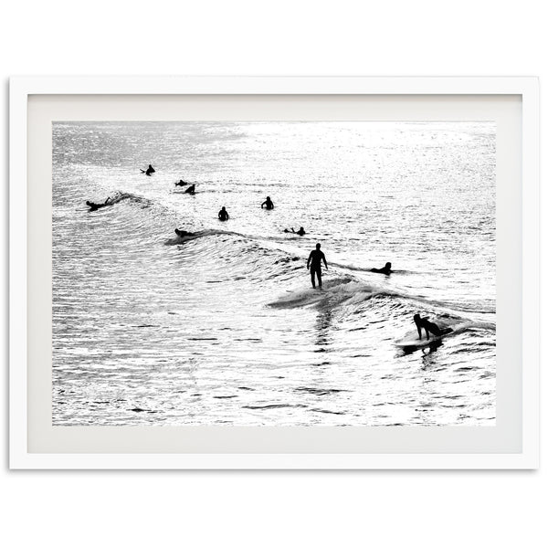 a black and white photo of surfers in the ocean