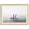 a black and white photo of a person swimming in the ocean