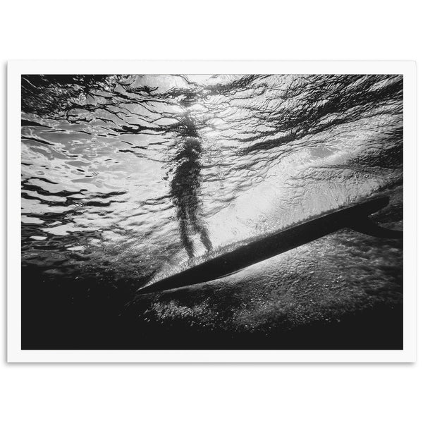 a black and white photo of a person on a surfboard