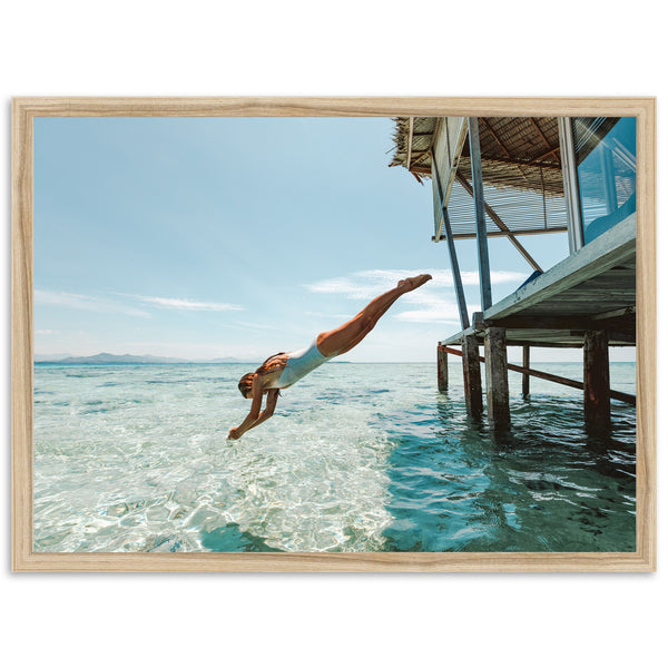 a man diving into the ocean from a dock