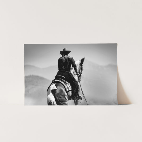 a black and white photo of a cowboy on a horse