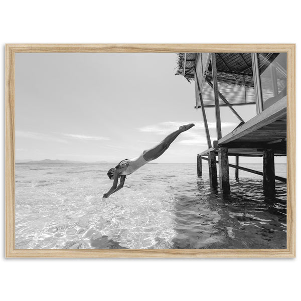 a black and white photo of a person diving into the water