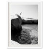 a black and white photo of a person jumping off a cliff into the ocean