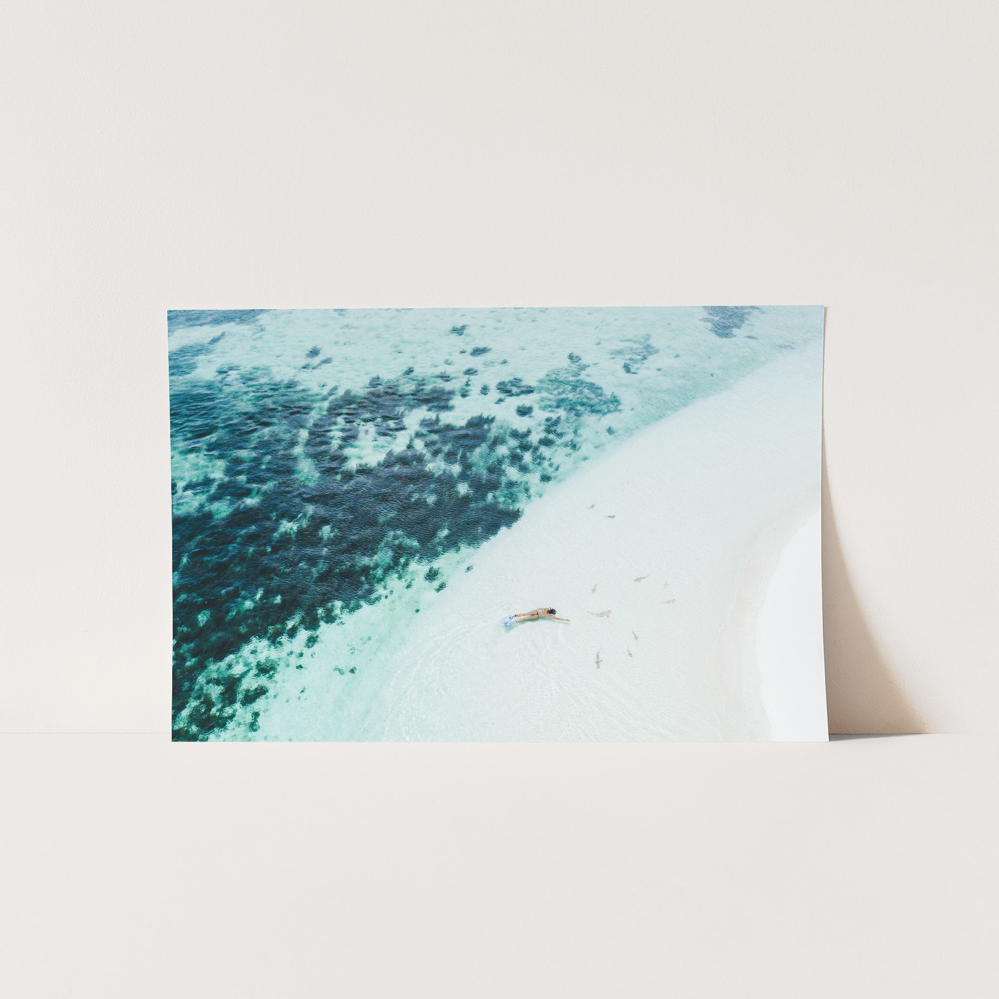 an aerial view of a beach with a boat in the water