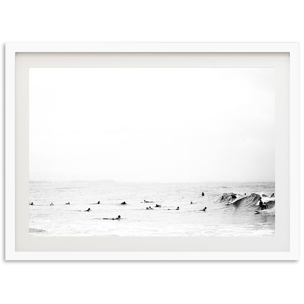 a black and white photo of surfers in the ocean