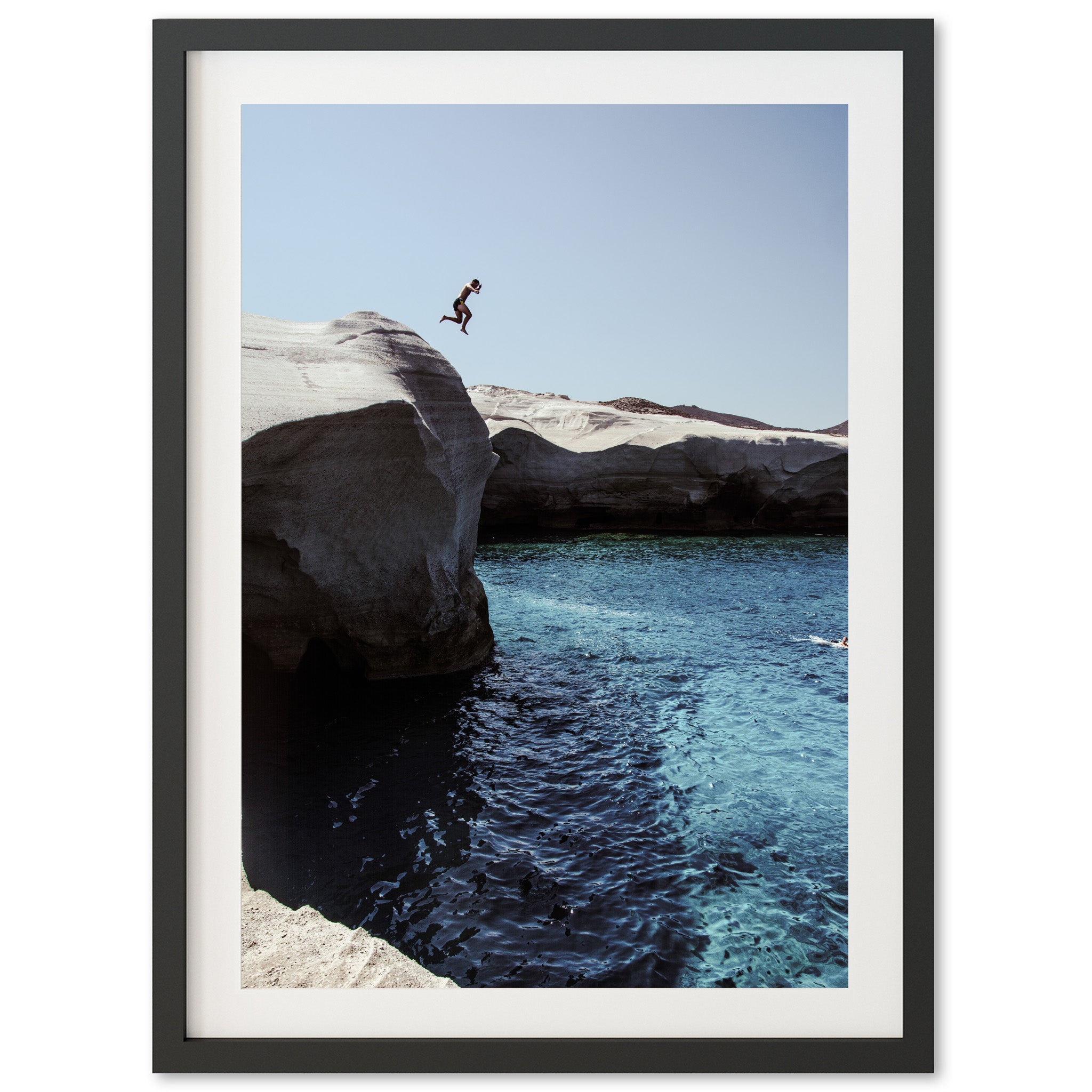 a person jumping off a cliff into a body of water