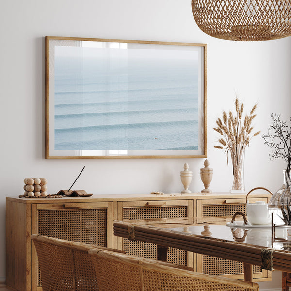 a dining room with a table and chairs and a picture hanging on the wall