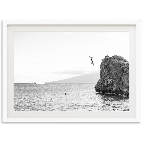 a black and white photo of a rock in the ocean