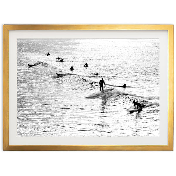 a black and white photo of surfers in the ocean