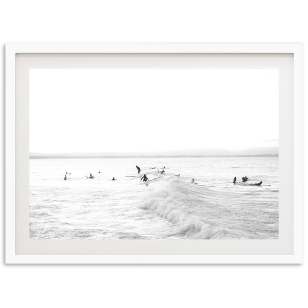 a black and white photo of surfers in the ocean