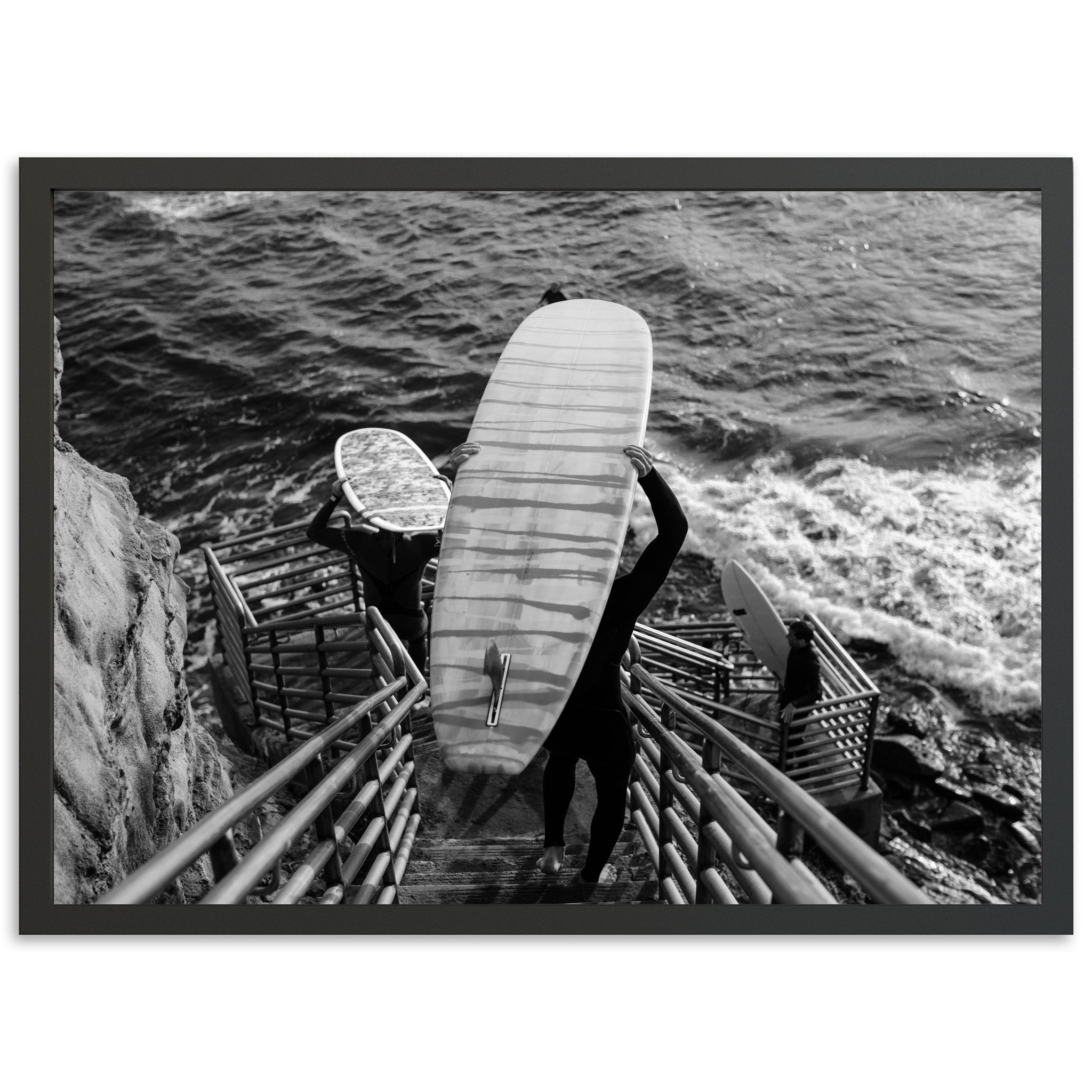 a black and white photo of a person holding a surfboard