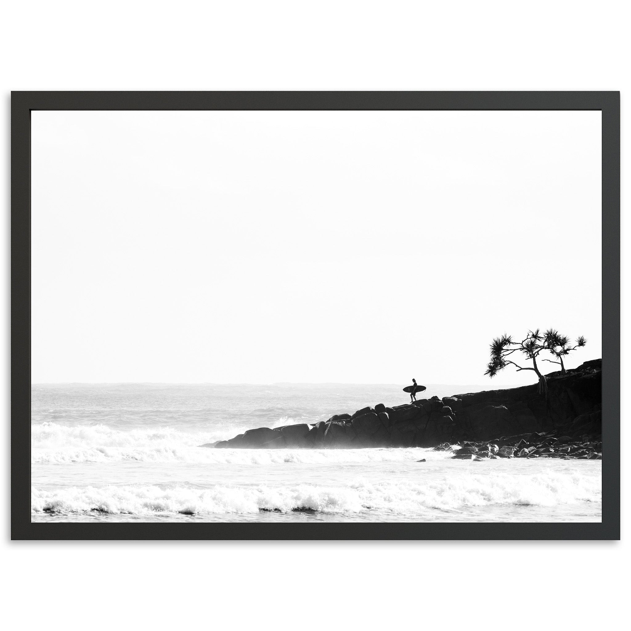 a black and white photo of a beach with a lone tree