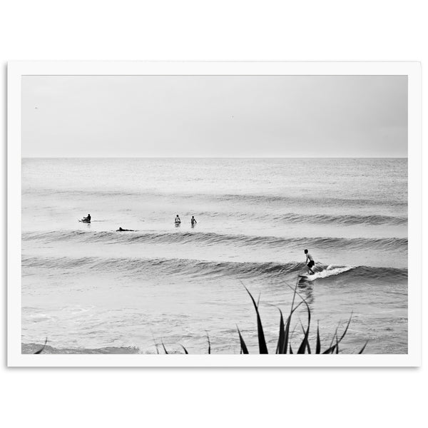 a black and white photo of people surfing in the ocean