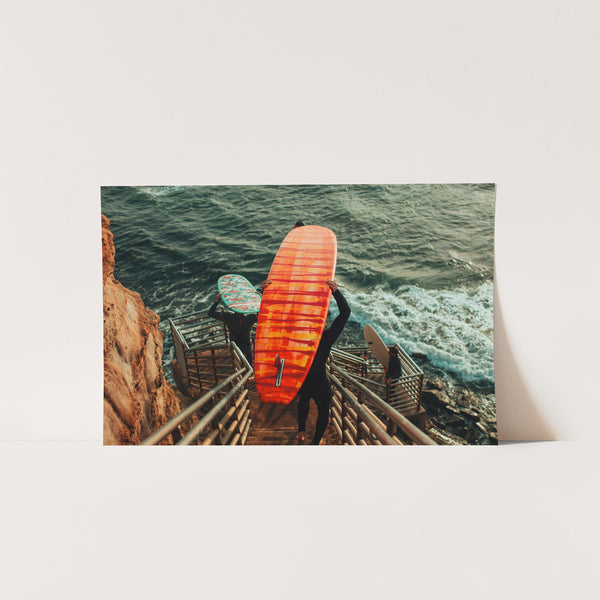 a man holding a surfboard on top of a stairway