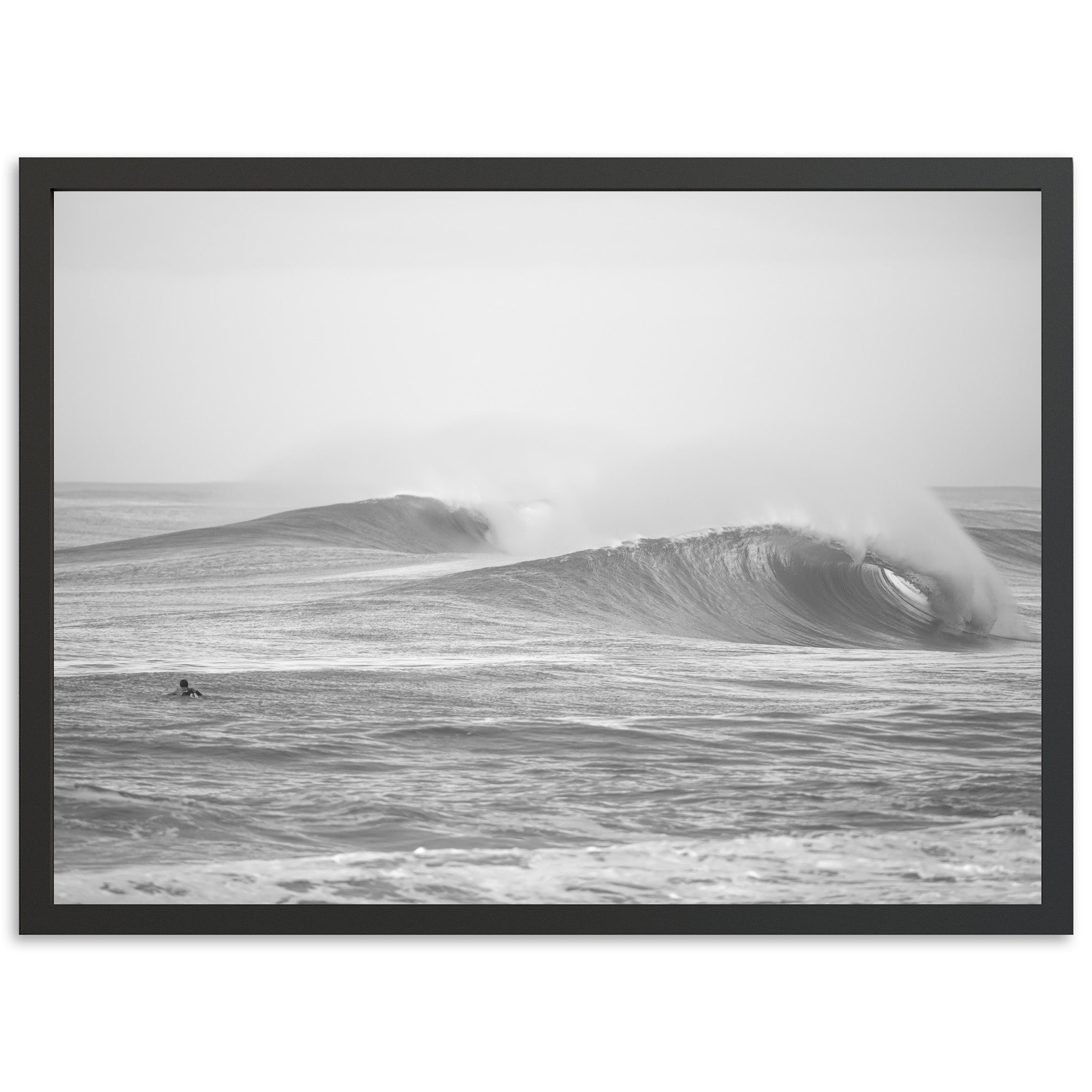 a black and white photo of a surfer riding a wave