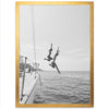 a black and white photo of two people jumping off a boat