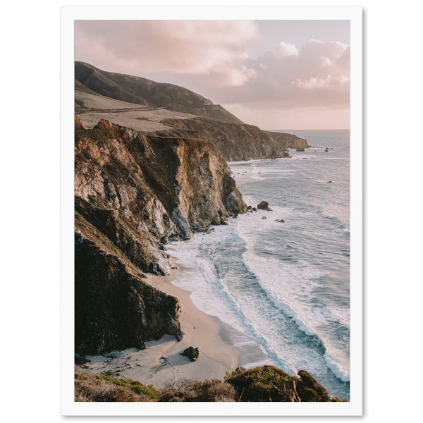 a picture of a beach with a cliff in the background