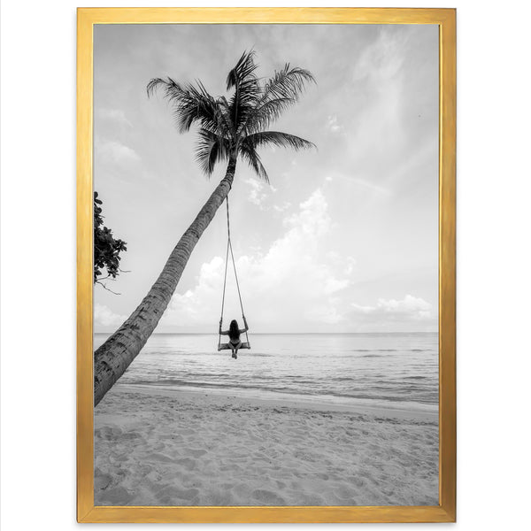 a black and white photo of a person swinging on a palm tree