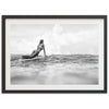 a woman laying on a surfboard in the ocean