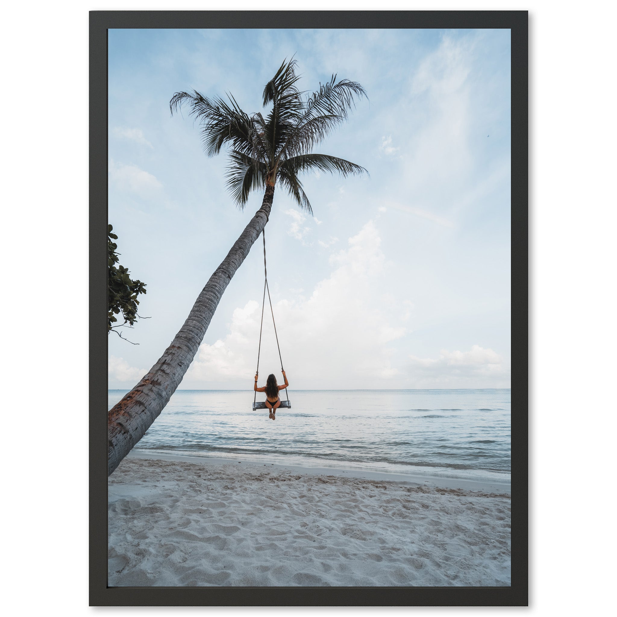 a woman sitting on a swing between two palm trees