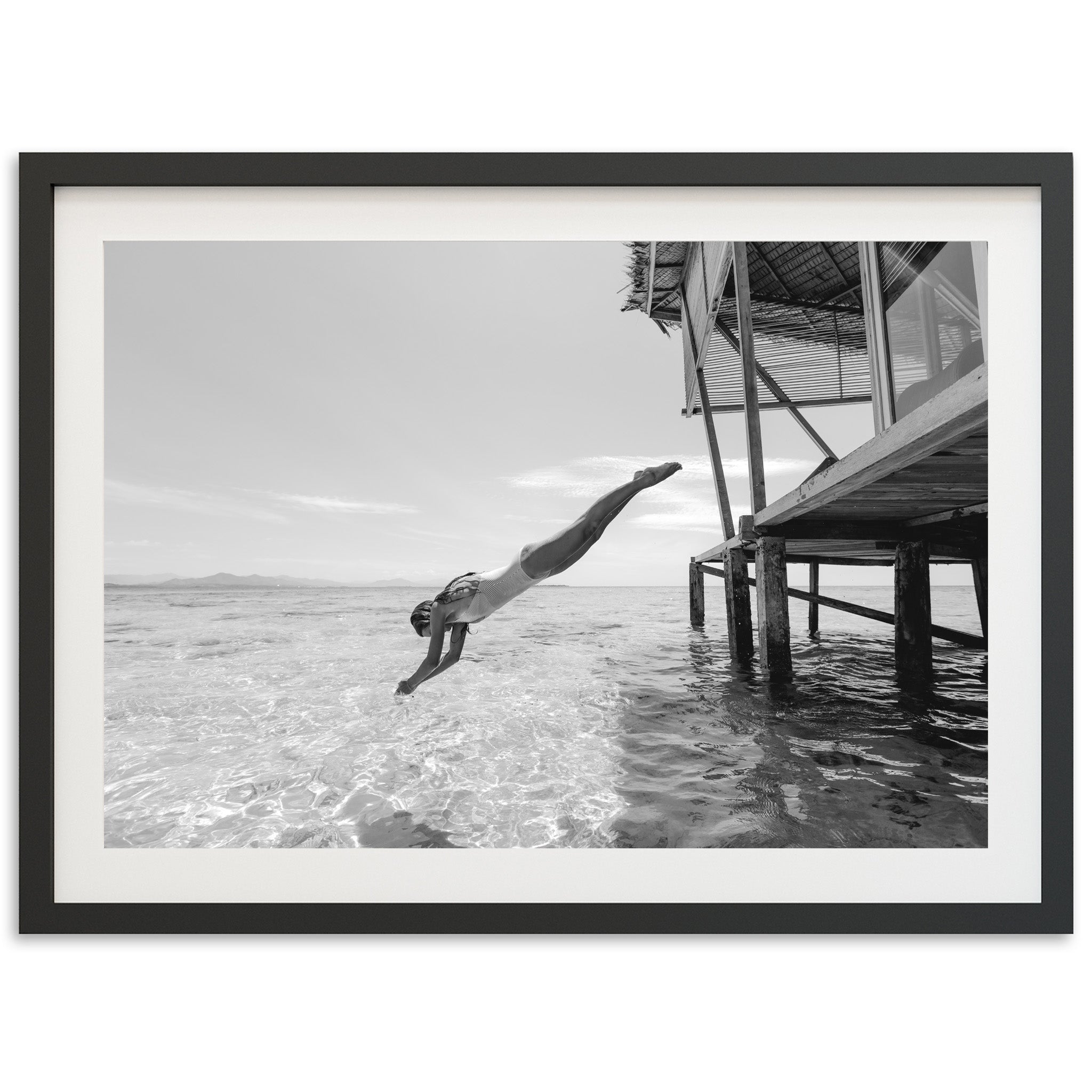 a black and white photo of a person diving into the water