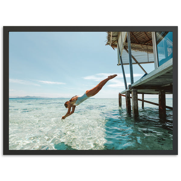 a man diving into the ocean from a dock