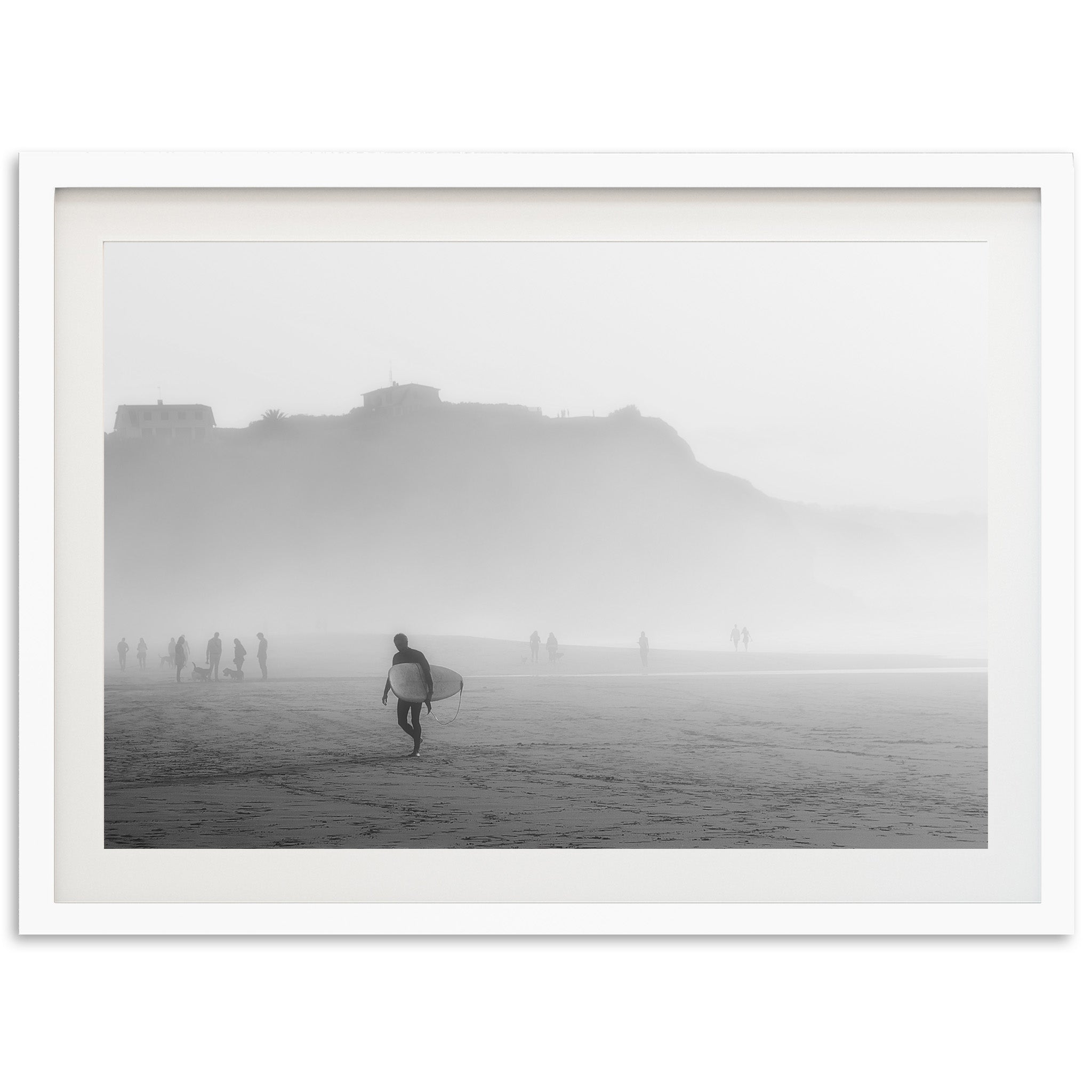 a black and white photo of a person carrying a surfboard