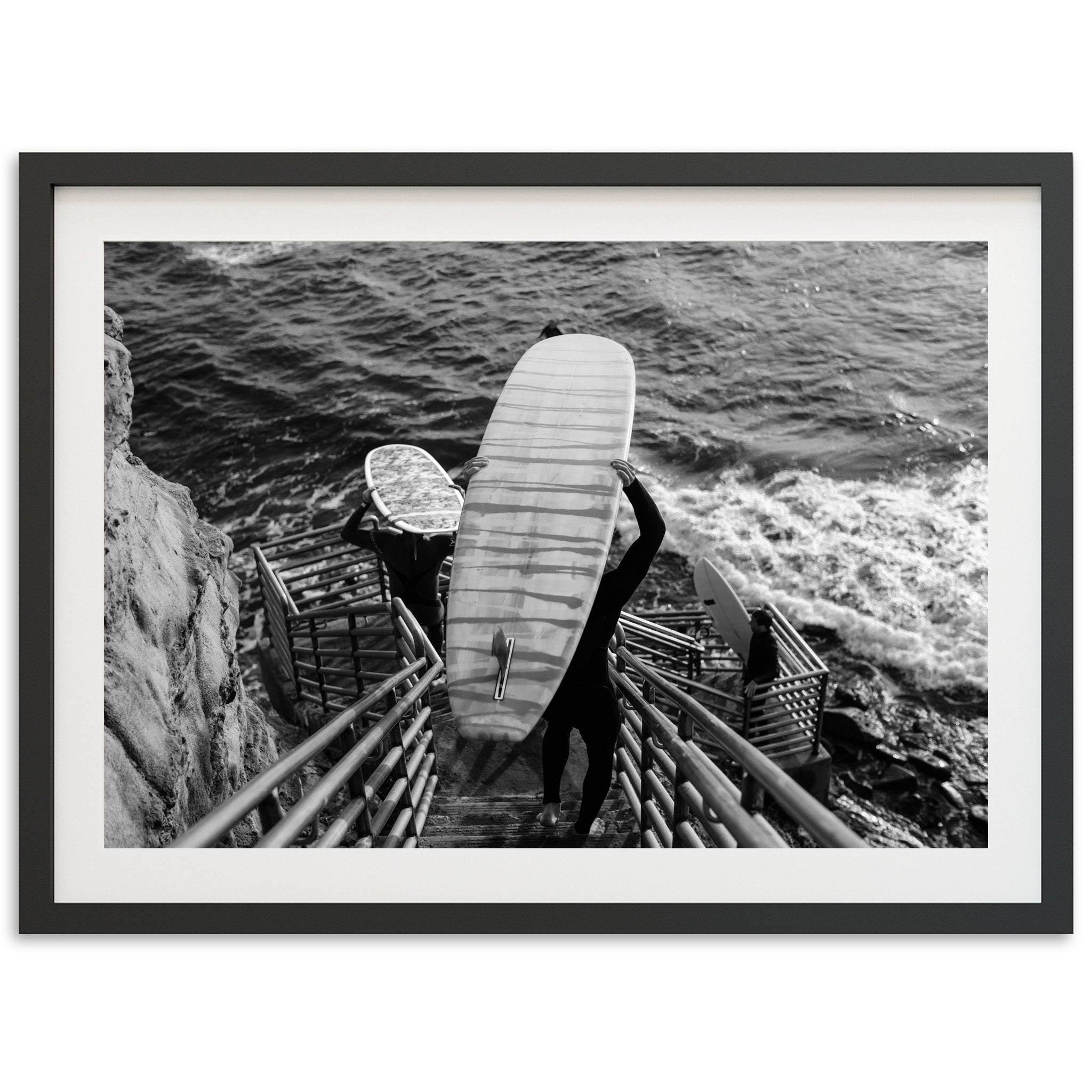 a black and white photo of a person holding a surfboard