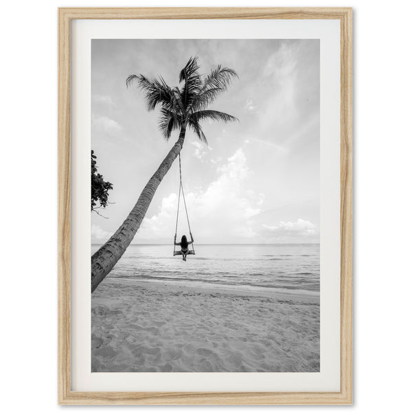 a black and white photo of a person swinging on a palm tree