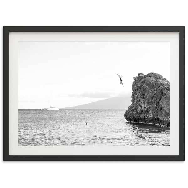 a black and white photo of a rock in the ocean