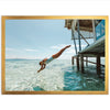 a woman diving into the ocean from a dock