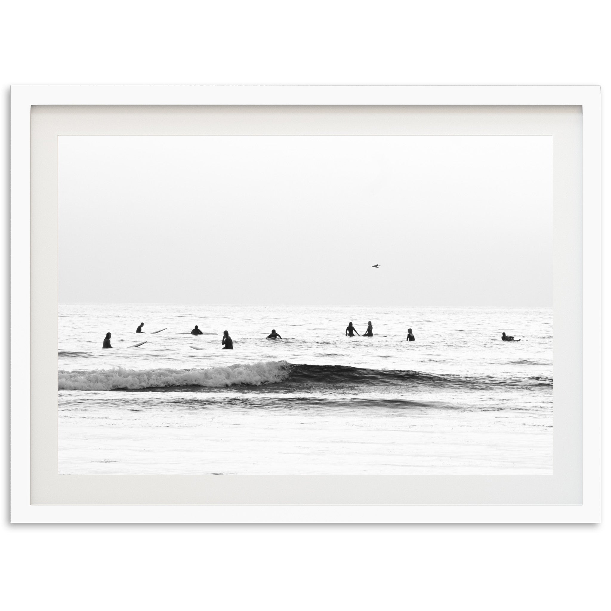 a black and white photo of surfers in the ocean