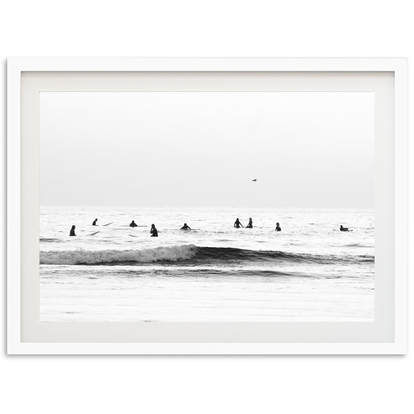 a black and white photo of surfers in the ocean