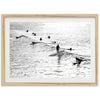 a black and white photo of surfers in the ocean