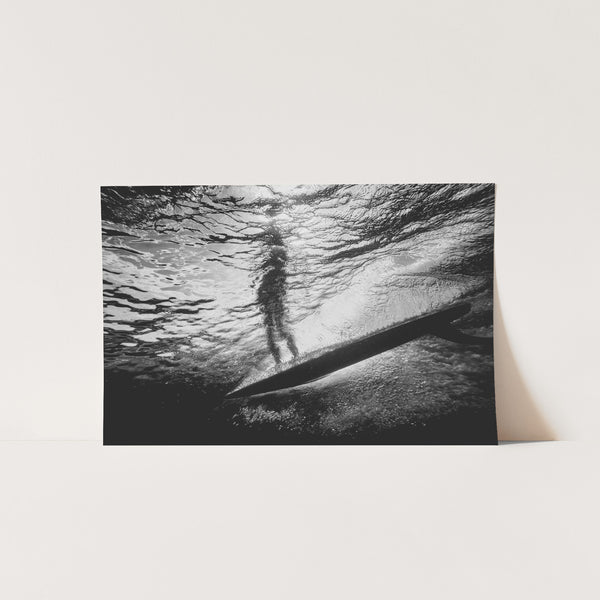 a black and white photo of a person on a surfboard