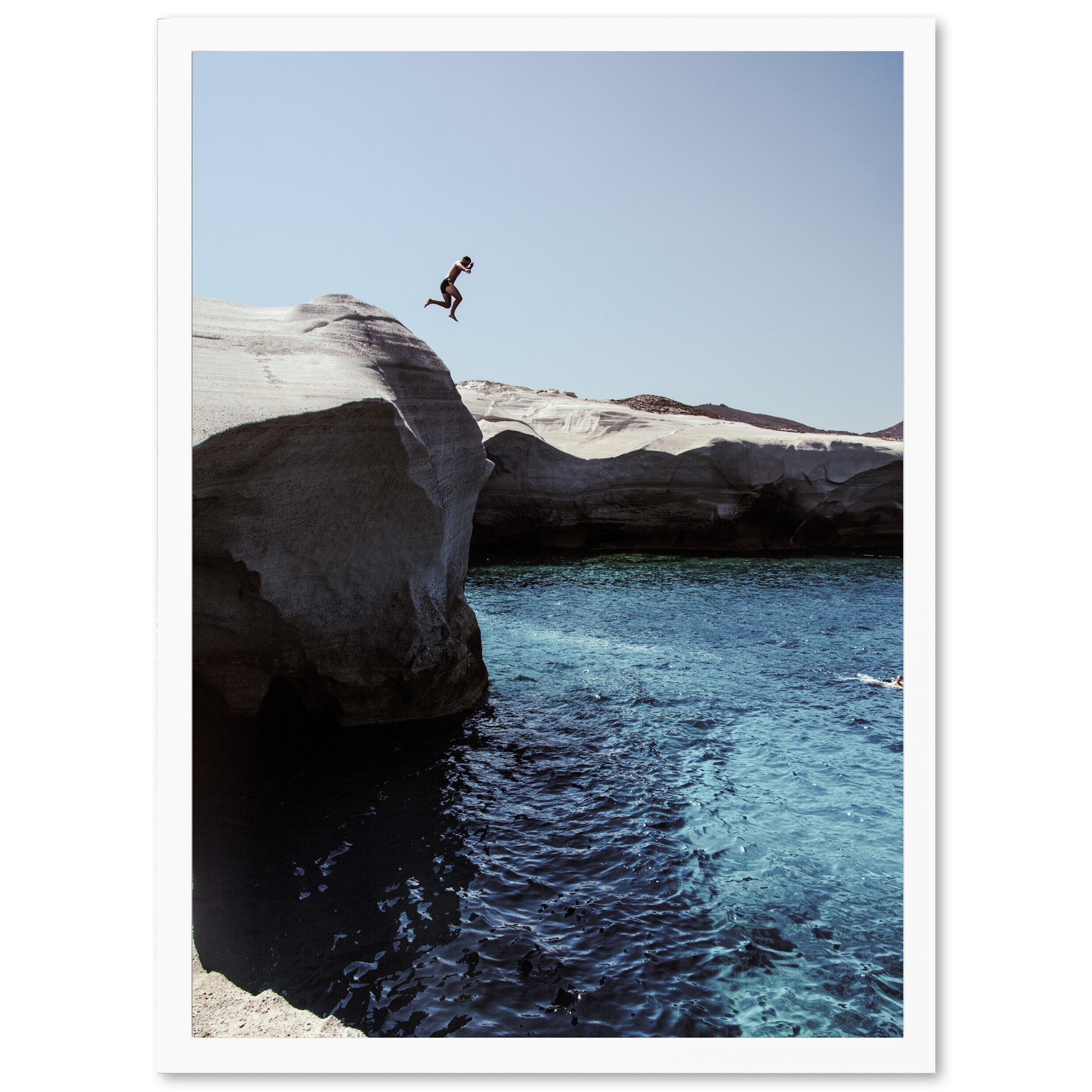 a person jumping off a cliff into a body of water