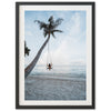 a person sitting on a swing between two palm trees