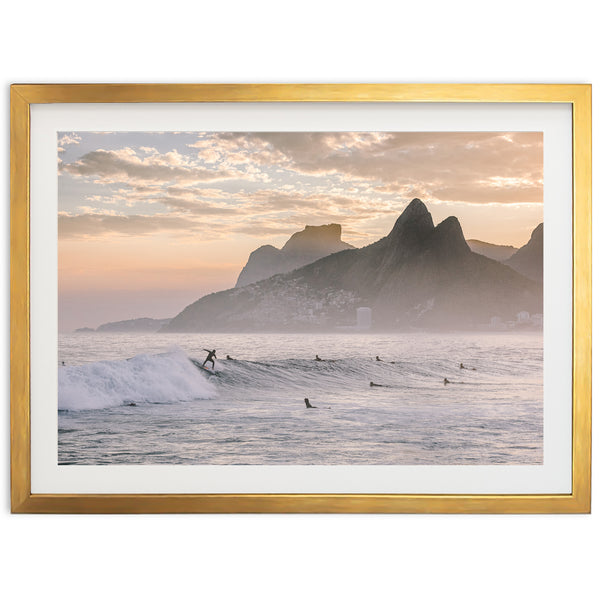 a picture of surfers in the ocean with mountains in the background