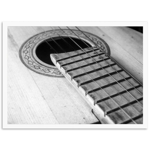 a black and white photo of an acoustic guitar