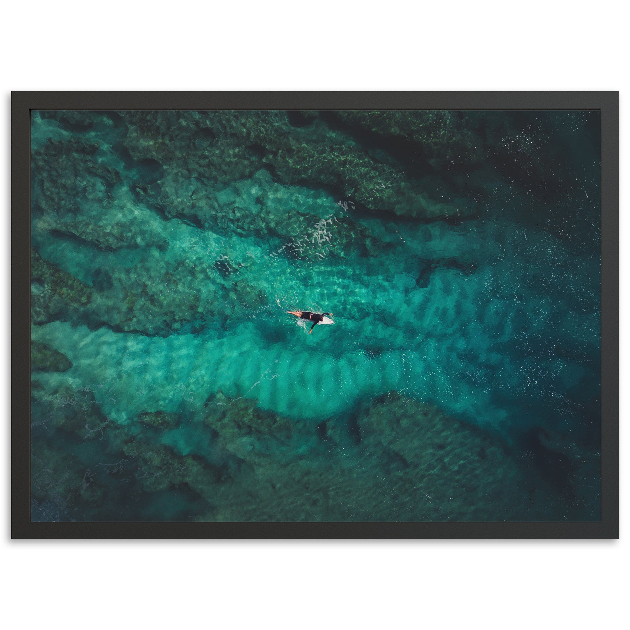 an aerial view of a person riding a surfboard in the ocean