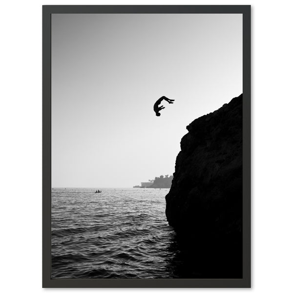 a black and white photo of a bird flying over the ocean