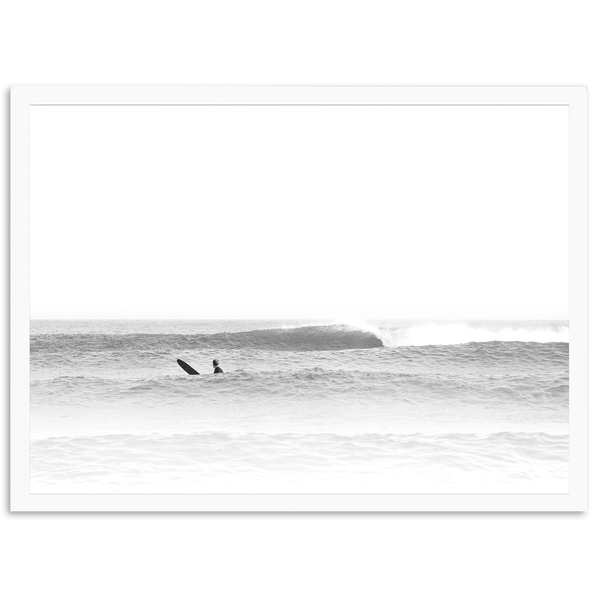 a black and white photo of two surfers in the ocean